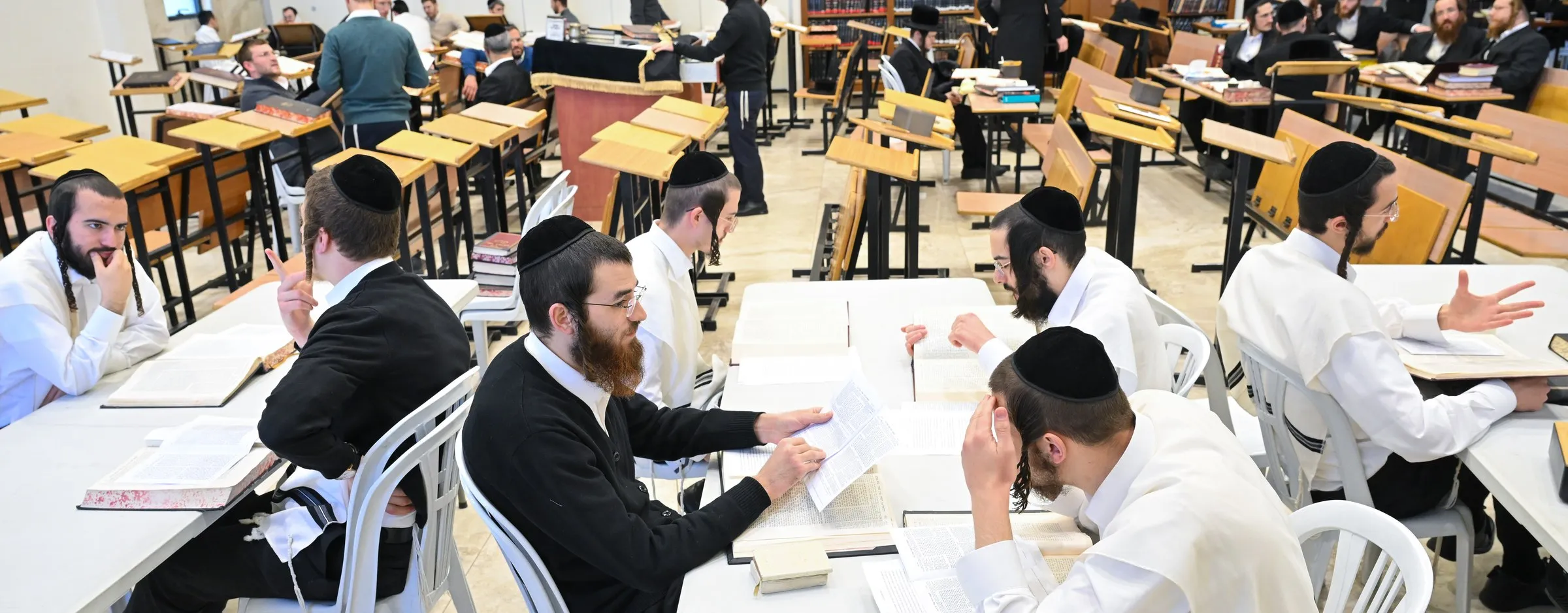 Yungeleit learning in chavrusos at white tables at Zichron Leib, Beitar Illit